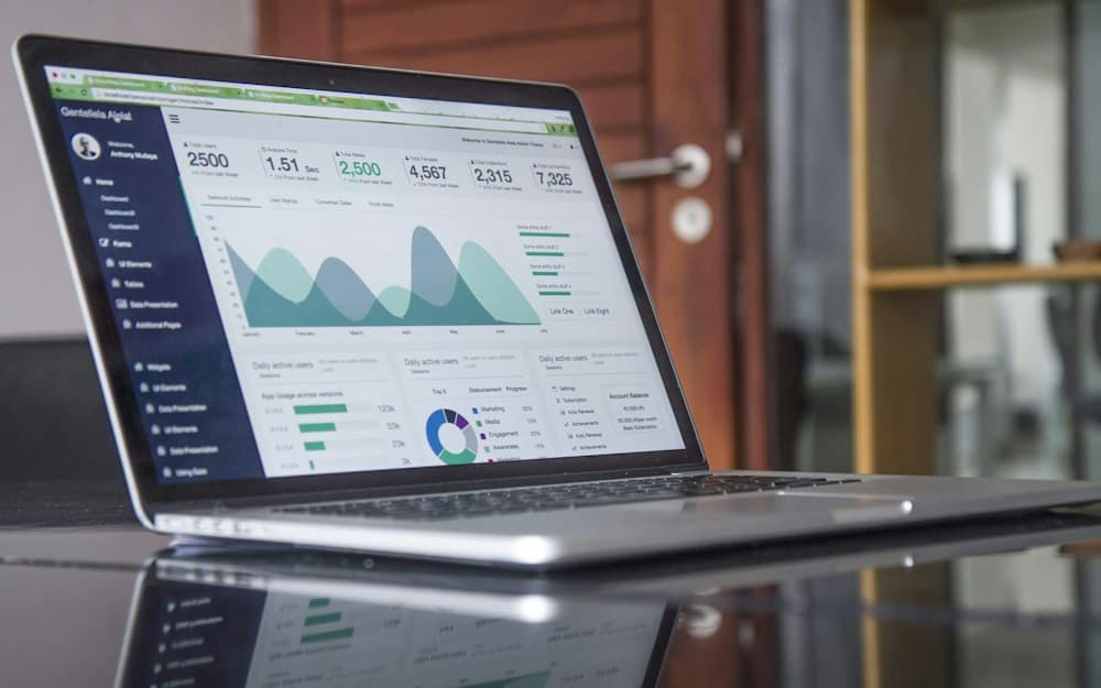 A laptop showing an analytics dashboard with charts and key metrics
